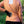 Person wearing orange long sleeve shirt with Hothands heat patch applied to lower back