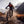 Mountain biker riding through a stream in a mountainous landscape