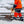 Worker in high visibility orange uniform shoveling snow from stone steps
