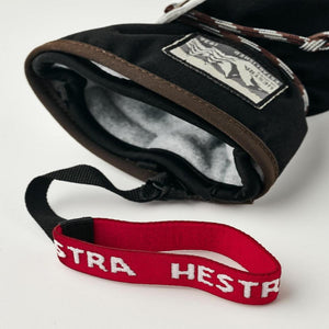 Black Hestra mitten with grey fleece lining and red wrist strap