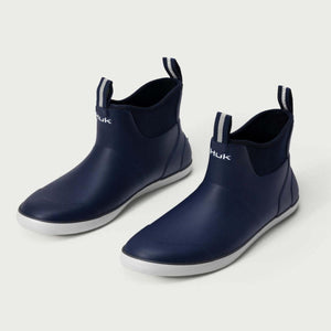 Pair of navy blue Huk ankle boots with white soles
