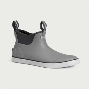 Grey ankle height Huk rubber boot with white sole and black pull tabs