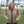 Woman wearing a tan HyperKewl quilted cooling vest over a red shirt outdoors