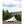 Snow Peak tent set up in a field with trees and hills in the background