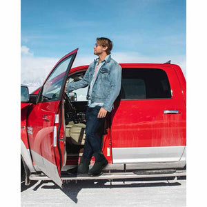Man wearing ThermalStep boots standing by a red truck in a snowy landscape