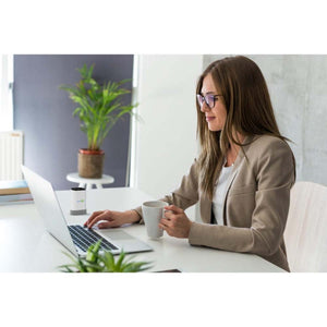 Woman working on laptop with HealthyLine device on desk