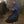 Mechanic kneeling on an Impacto mat while using a pneumatic tool on a car wheel