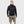 Man wearing a black FjallRaven hooded fleece jacket and olive green cargo shorts
