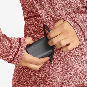 Venture Heat battery pack being placed into a zippered pocket of a red heathered jacket