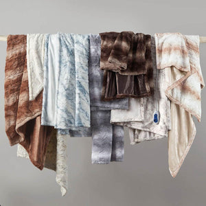Beautyrest heated faux fur throw blankets in various colors hanging on a rod