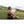 Woman sitting on grass using an ExtremeMIST personal cooling mister