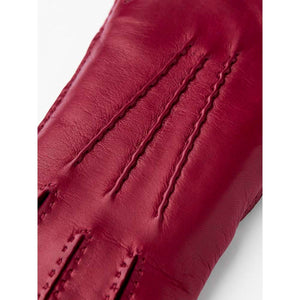 Close up of red Hestra leather glove with decorative stitching on the back