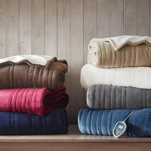 Stacks of folded Woolrich heated blankets in various colors with a digital controller