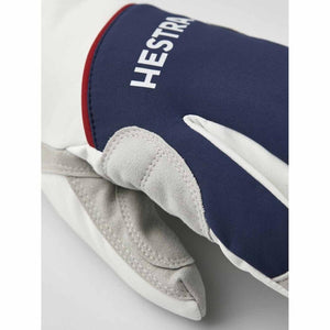 Close up of a white and blue Hestra ski glove with grey suede palm detail