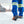 Worker wearing blue high visibility trousers and ice cleats on boots walking in snow