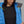 Close up of a person wearing a blue FjallRaven hooded jacket over a black shirt