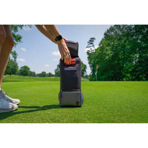 Person placing a drink into a Kanga Coolers insulated sleeve on a golf course