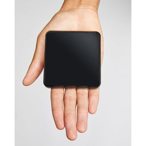 Kelvin square black device held in an open palm