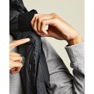 Person pressing the power button on a Kelvin heated vest