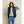 Model wearing a black Kelvin hooded puffer vest over a grey sweatshirt and blue jeans