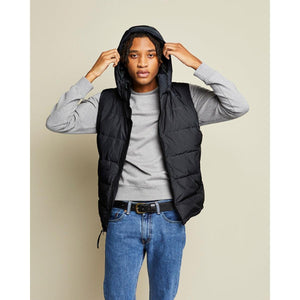 Model wearing a black Kelvin hooded puffer vest over a grey sweatshirt and blue jeans
