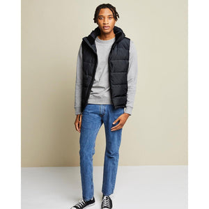 Man wearing a Kelvin black hooded puffer vest over a grey sweatshirt and blue jeans