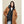 Model wearing a Kelvin brown wool coat layered over a black hooded puffer vest
