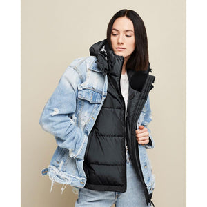 Kelvin distressed denim jacket layered over a black puffer vest