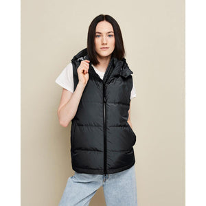 Woman wearing a black Kelvin hooded puffer vest over a white t-shirt and blue jeans