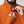Close up of a person wearing an orange FjallRaven zip up fleece with thumb holes