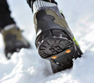 Korkers traction cleats on a boot walking through snow
