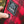 Hand pressing a Kuma Outdoor Gear power button on red and black plaid fabric