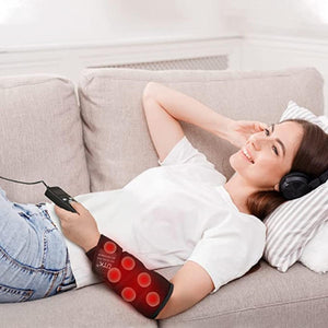 Person wearing a UTK Technology infrared heating pad on their forearm while resting on a sofa
