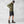 Man wearing FjallRaven olive green zip jacket black cap dark shorts and brown hiking boots
