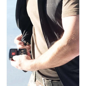 Person attaching a Lenz battery pack to a heated vest using snap fasteners