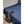 Black bed cooling unit with flexible hose extending onto a blue bedspread