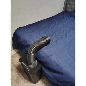 Black bed cooling unit with flexible hose extending onto a blue bedspread