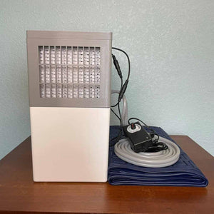 Mattress Cooler unit with power adapter and blue cooling mat on a wooden surface
