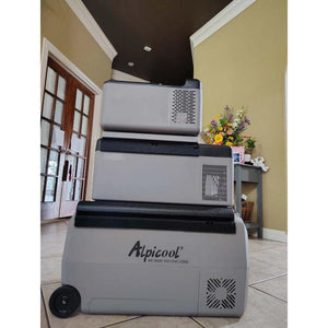 Three Alpicool portable refrigerators stacked vertically on a tiled floor