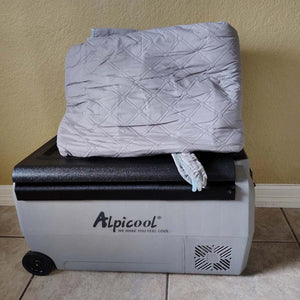 Mattress Cooler quilted grey mattress pad folded on top of an Alpicool portable refrigerator