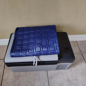 Mattress Cooler unit with a blue grid patterned cooling pad folded on top