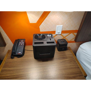 Mattress Cooler unit on a wooden nightstand next to a telephone and alarm clock