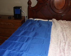 Mattress Cooler cooling pad on a bed with a connected cooling unit on the nightstand