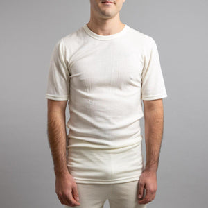 Man wearing a cream Merino Skins short sleeve crew neck base layer shirt