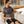 Man sitting on a sofa using a black Mihigh infrared heating pad on his lap