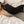 Person lying on bed wearing a black quilted MiHIGH infrared heating pad on their lower back