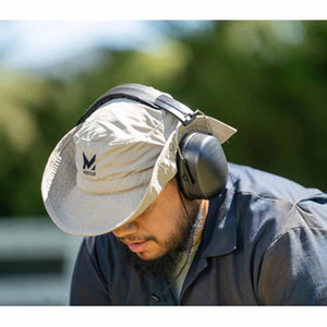 Person wearing a Mission brand beige sun hat and black protective earmuffs
