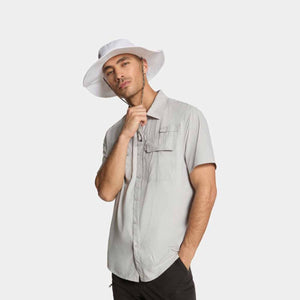 Man wearing a white Mission bucket hat and a light grey short sleeve button down shirt