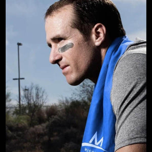 Man wearing a grey shirt and a blue Mission cooling towel around his neck