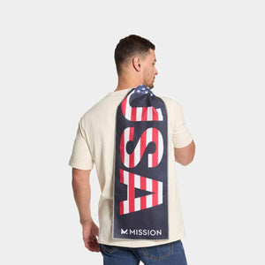 Man wearing a cream t-shirt with a Mission cooling towel featuring USA flag print draped over his shoulder